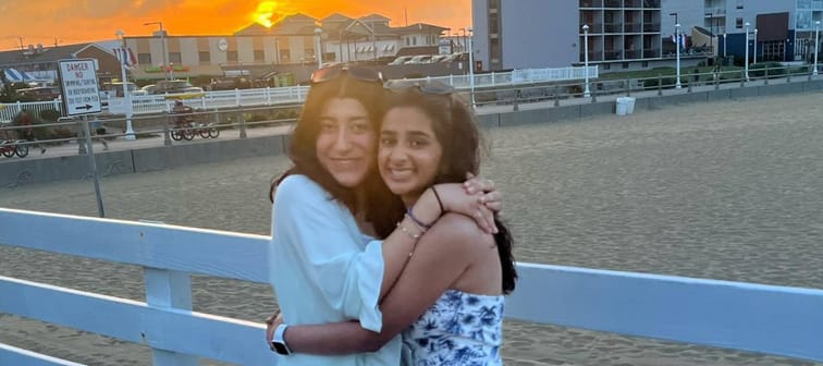 Anusha Ahmed and her friend standing on a dock during sunset
