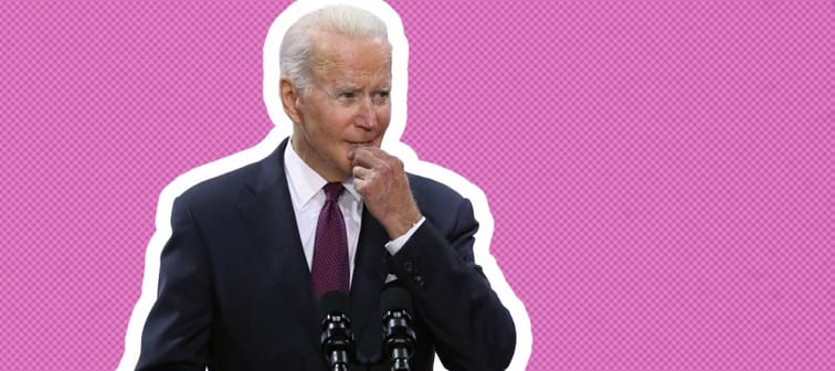 Joe Biden stands at a podium looking unsure with his hand on his chin.