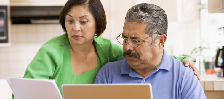 Older couple looks surprised while going through documents.