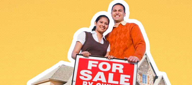 Couple pose proudly in front of home, with hands on For Sale By Owner sign.