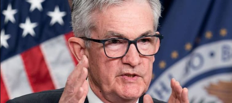 Federal Reserve Chairman Jerome Powell gestures with his hand while speaking at a press conference.