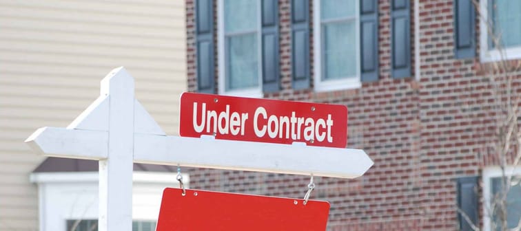 real estate for sale with under contract sign in red