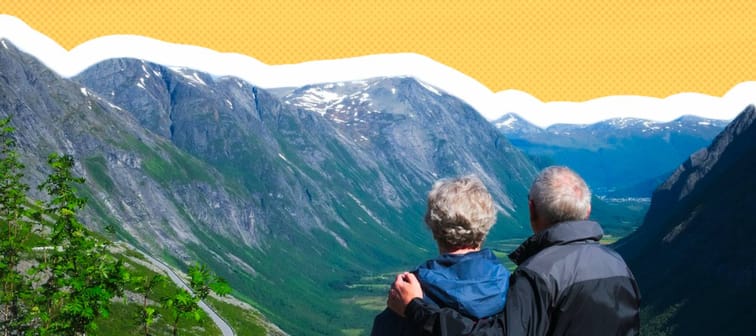 Older couple seen from behind, taking in the view of mountains and valleys in Norway.