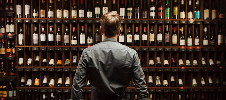 Man standing in front of wine collection
