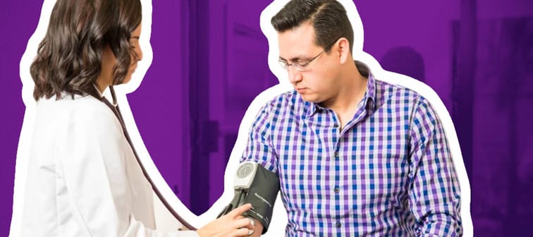 Young doctor measures man's blood pressure while he looks down at the cuff she's using.