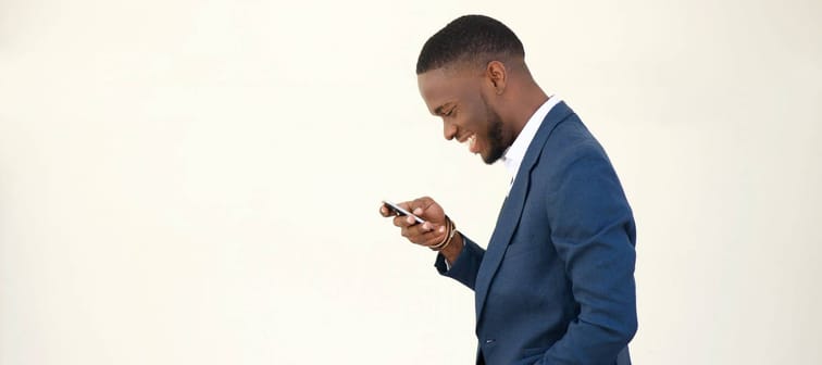 A man smiling and looking at his phone