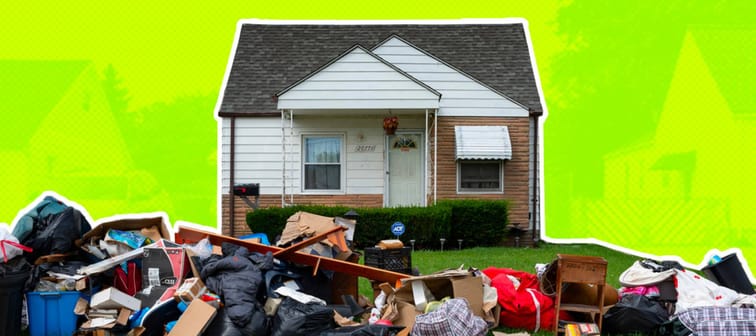 Small suburban home with all the belongings piled out front on the lawn.