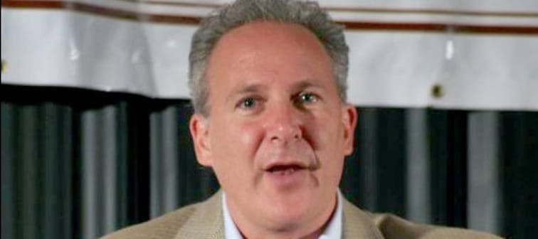 Peter Schiff speaks at a podium, mouth open while talking.