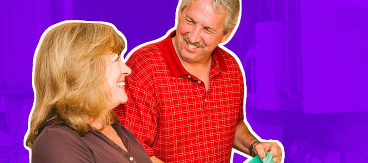 Happy mature couple doing dishes together and smiling.
