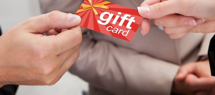 Close-up Of Businessperson Hands Giving Gift Card To Other Businessperson