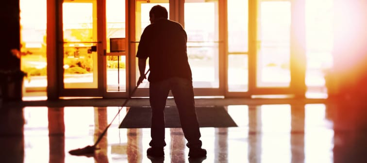 Janitor mopping an office floor, shallow focus, tilt shift image.