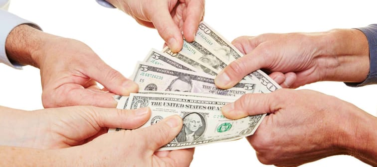 Many hands of senior people holding dollar money bills