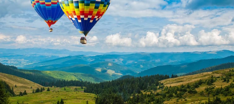 Colorful hot-air balloons flying over the mountains. Artistic picture. Beauty world