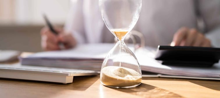 Accountant Calculating Invoice Bill In Time With Hourglass