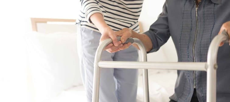 walk training and rehabilitation process, stroke patient use walker with care giver