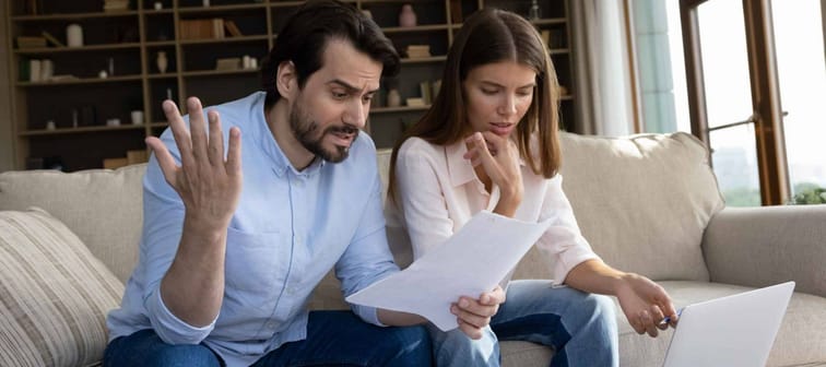 Couple reviewing bills feels stressed having financial problem
