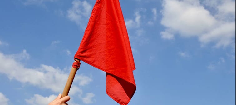 Hand waving a red flag in the sky
