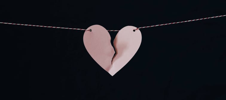 Paper heart torn in half held up by a piece of string