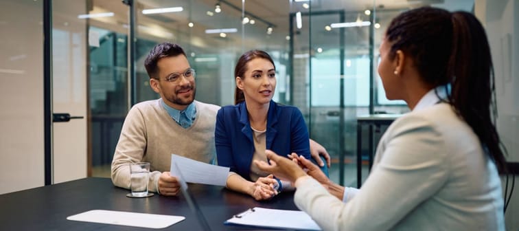 a couple talking to a financial advisor in an office setting