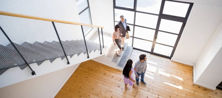 overhead view of two couples looking around a house that is for sale