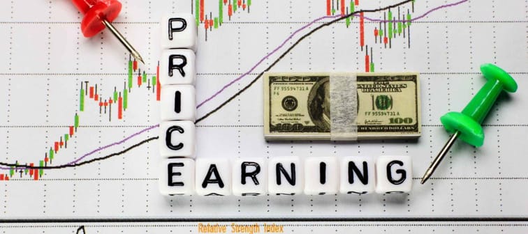 Price and Earning letter cube on candle stick chart background. Investment concept for P/E ratio.