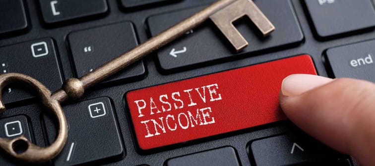 Closed up finger on keyboard with word PASSIVE INCOME