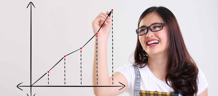 Fun cheerful school teenage girl drawing a chart with ascending line