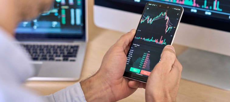 Crypto trader investor broker using smartphone app analyzing financial data stock market price on cell phone