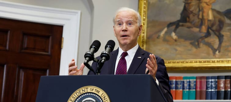 President Joe Biden speaks at the White House behind an official podium.