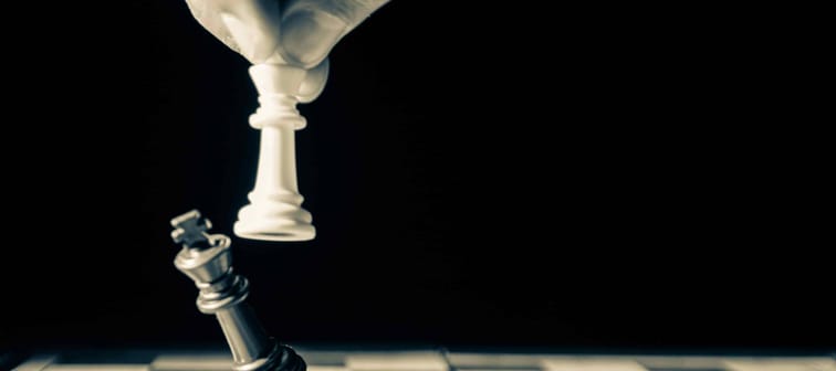 Bitbuy vs. coinbase  - two king chess pieces shown on chess board with one knocking over the other