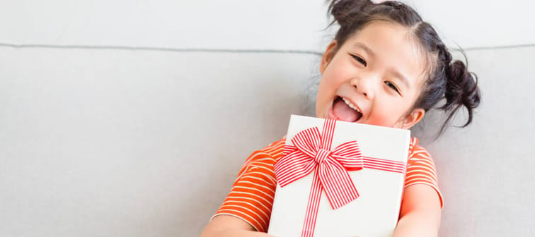 Little Asian girl holding a gift box