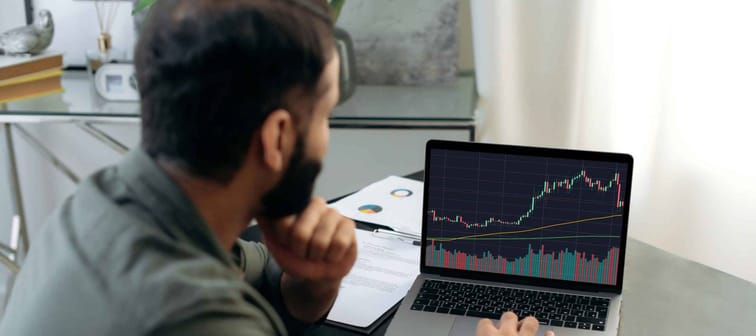 Smart broker investor, uses a laptop to analyze the financial market of cryptocurrencies