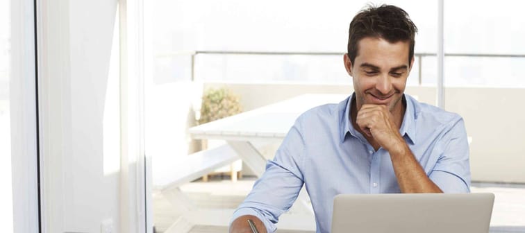 Dude working from home with laptop, smiling
