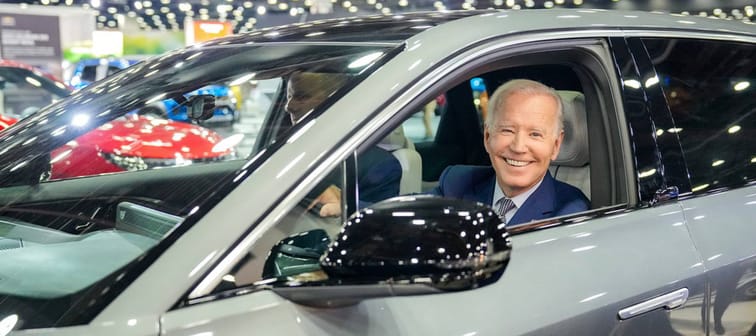 President Joe Biden has his photo taken while sitting in a vehicle.