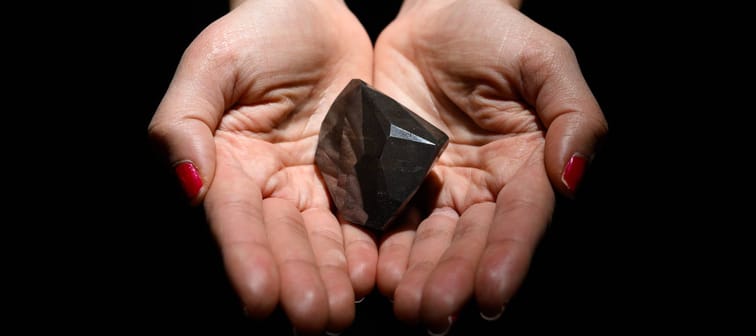 A member of the Sotheby's auction house team holds "The Enigma" black diamond in London, U.K., Feb. 4, 2022.