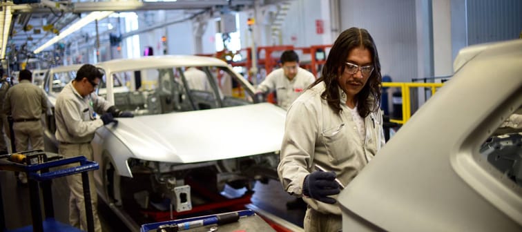 Employees work on the assembly line building the Tiguan model of vehicles at the Volkswagen plant in Puebla, Mexico, March 16, 2018.