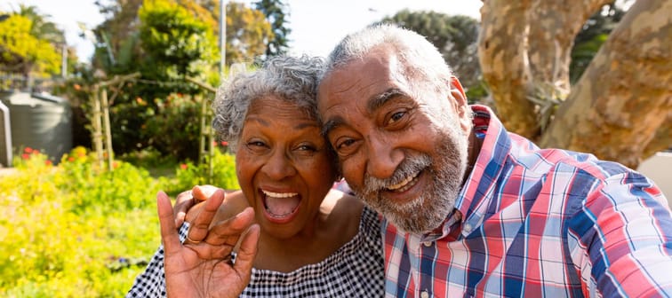 Happy older couple pose for a selfie in the garden.