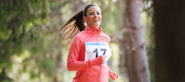 Woman running a race in the woods.