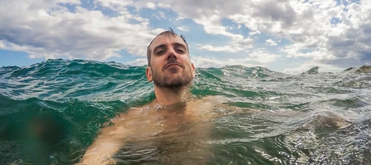 Man taking a selfie while swimming in open water.