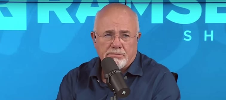 Dave Ramsey speaks into the microphone making a sassy face while on set of his radio show.