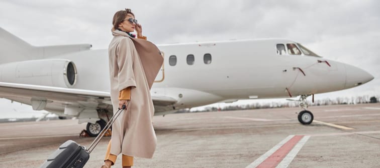 business woman in coat near her jet in airport