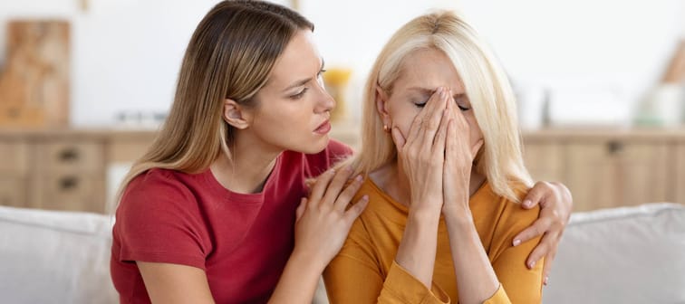 A young woman comforts an older one.