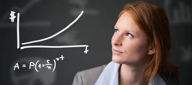 Young redheaded businesswoman contemplates a compound interest chart.