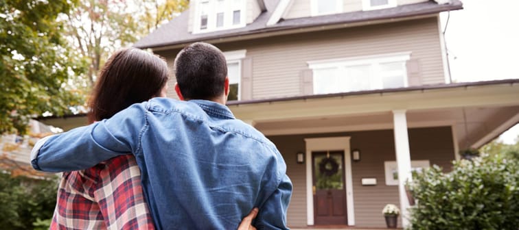 Rear View Of Loving Couple Looking At House