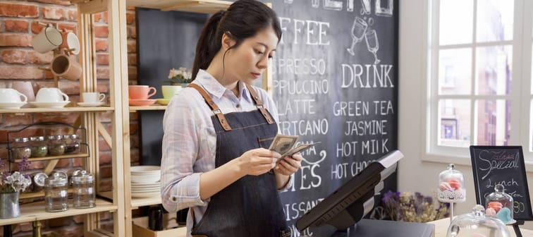 A barista counts money.