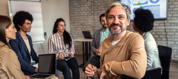 Portrait of businessman hosting a meeting while sitting in circle.