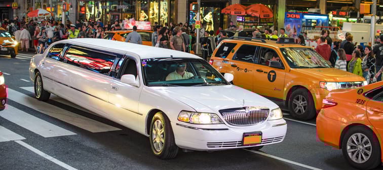 Street scene with an impressive stretch limo stuck in traffic at Times Square - Manhattan, New York.