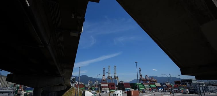 The head of Canada's biggest trucking firm says the U.S. election is softening an already weak market for freight. A transport truck carries a cargo container at port in Vancouver, on Friday,