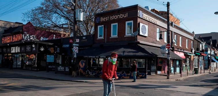 A new report lays out how an innovative funding model for community groups could be scaled up. A man scooters down an empty Kensington Market in Toronto, Wednesday, April 7, 2021. 