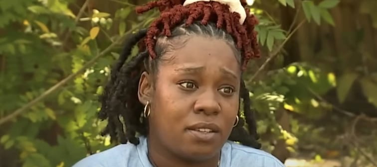 Woman sitting in backyard, speaking, looking off to the side.